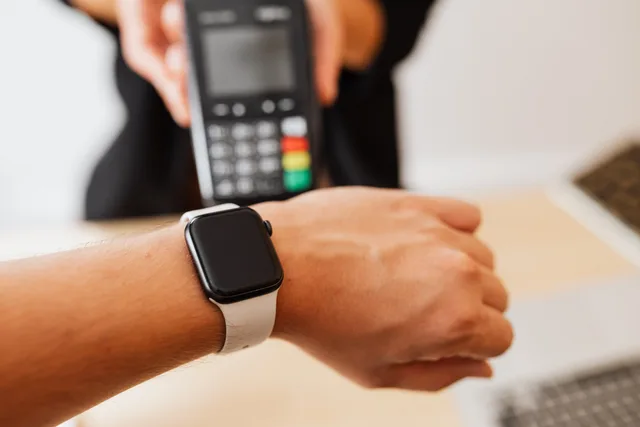Person making a contactless payment using a smartwatch at a cashless checkout counter. Sådan afstemmer du MobilePay og kortbetalinger i bogholderiet